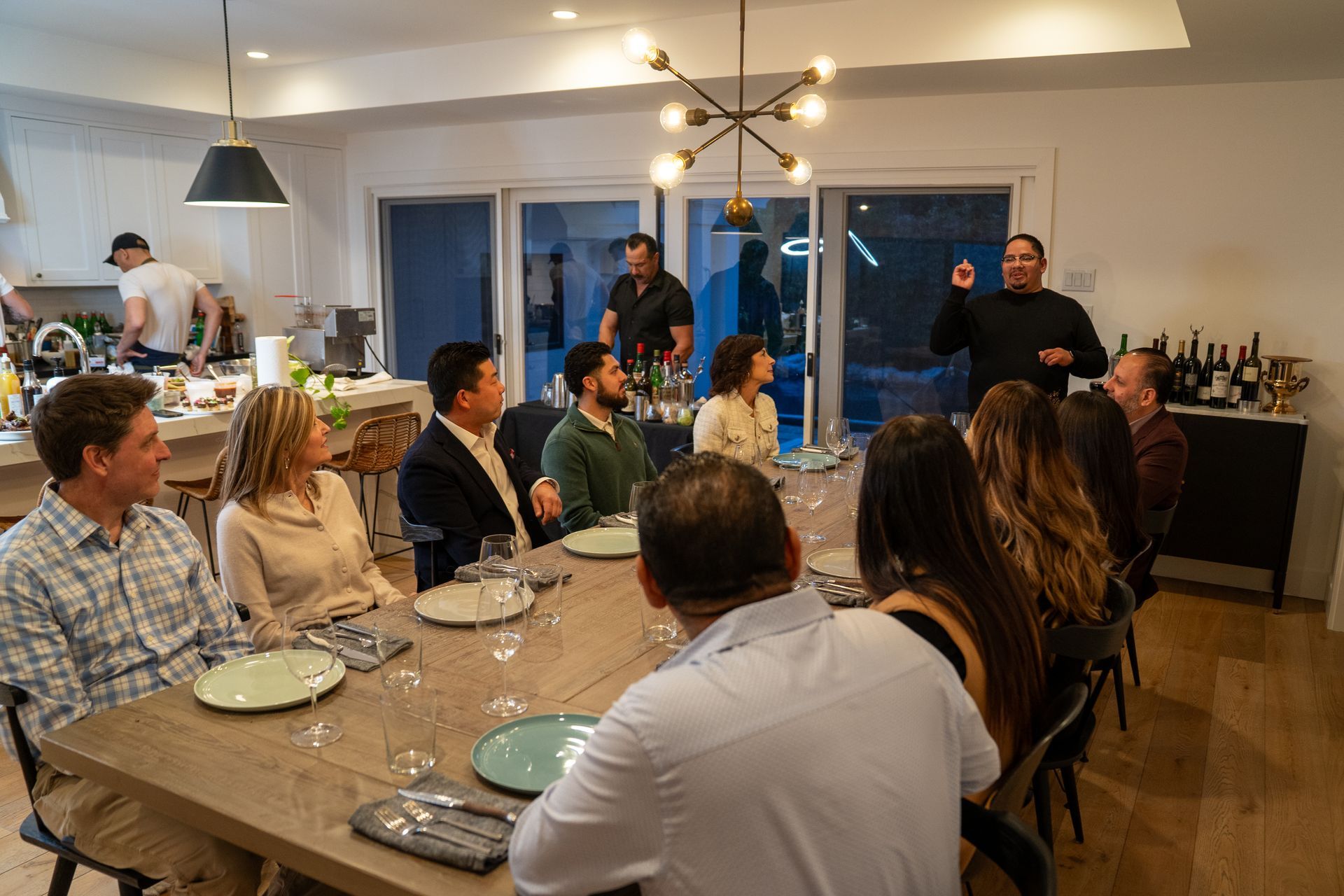 A group of people are sitting around a table in a living room.