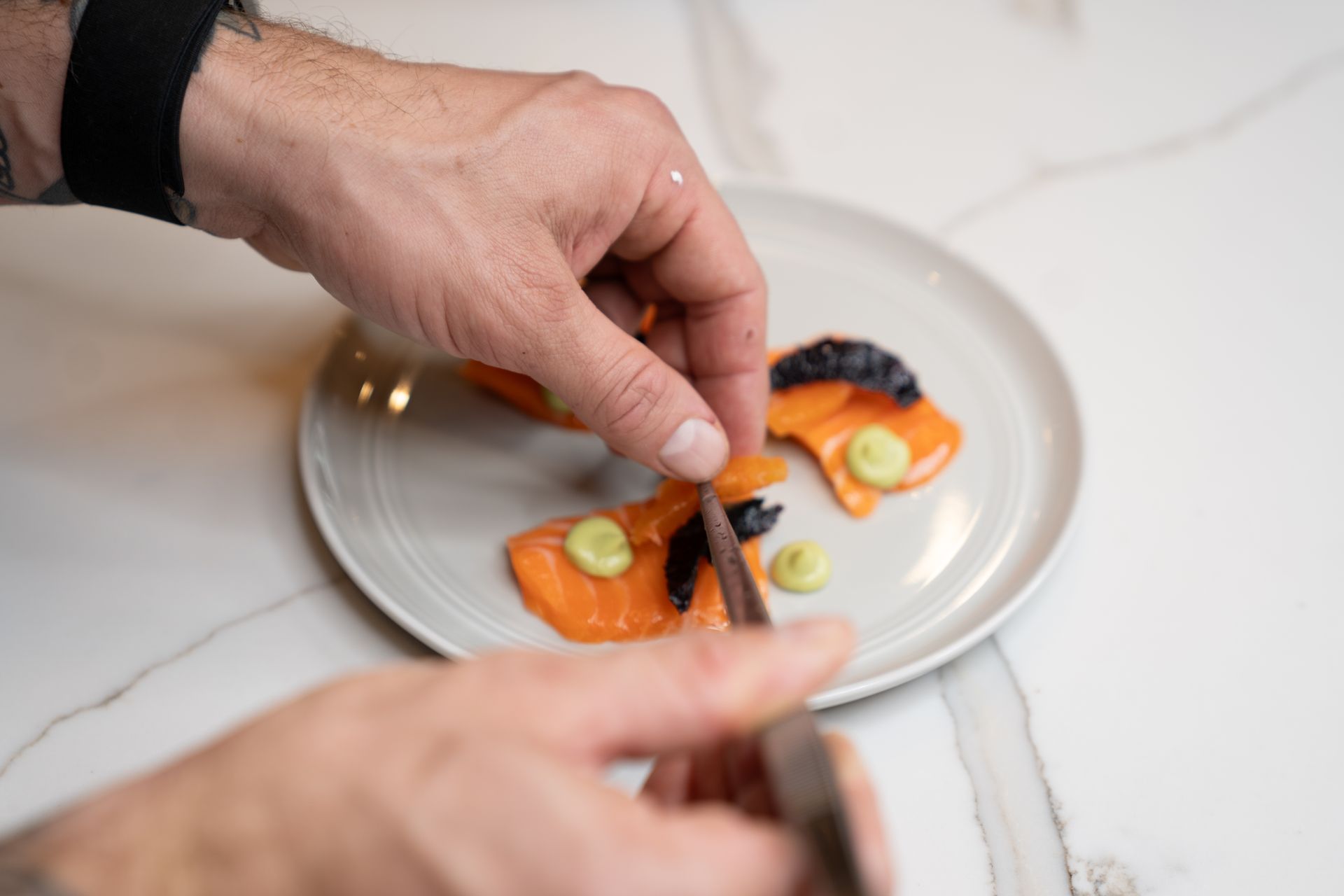 A person is preparing a plate of food on a table.