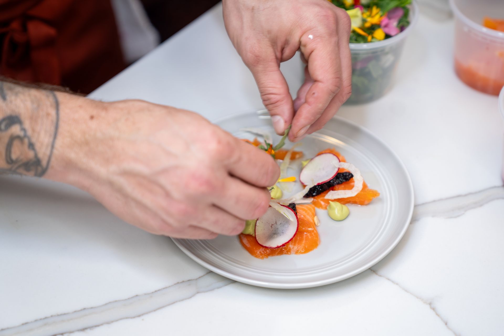 A person is preparing a plate of food on a table.