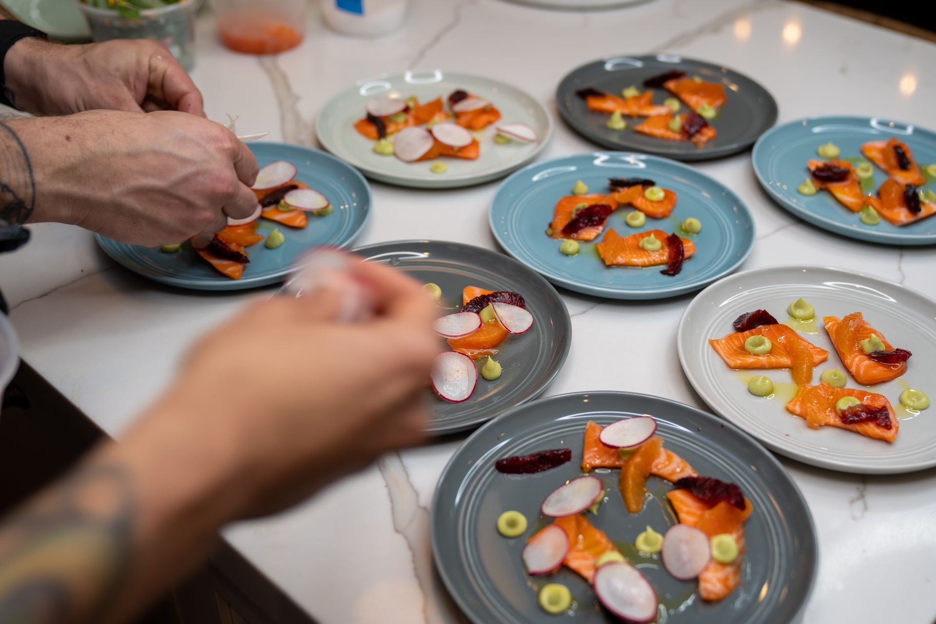 A person is preparing plates of food on a table.