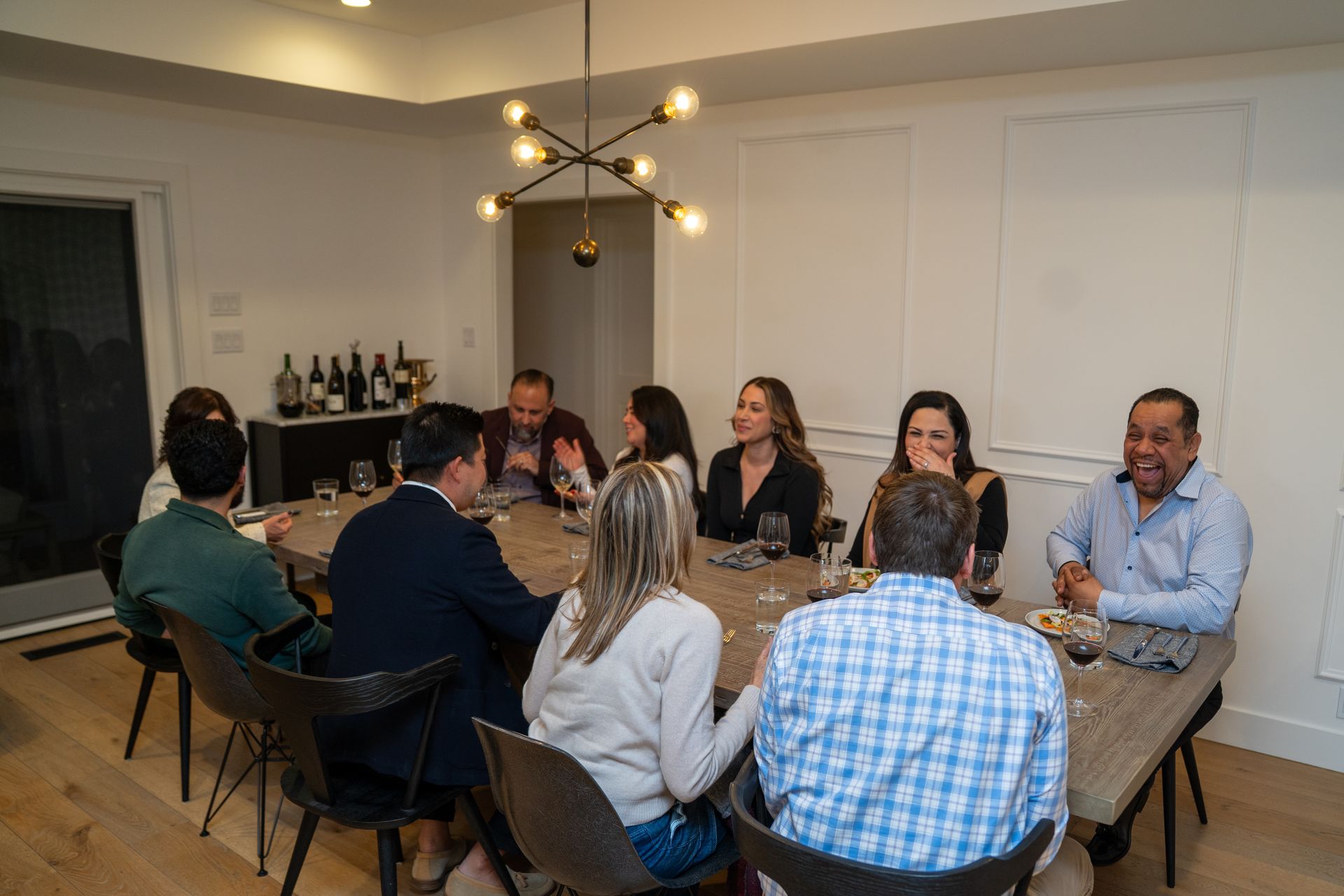 A group of people are sitting around a table in a dining room.