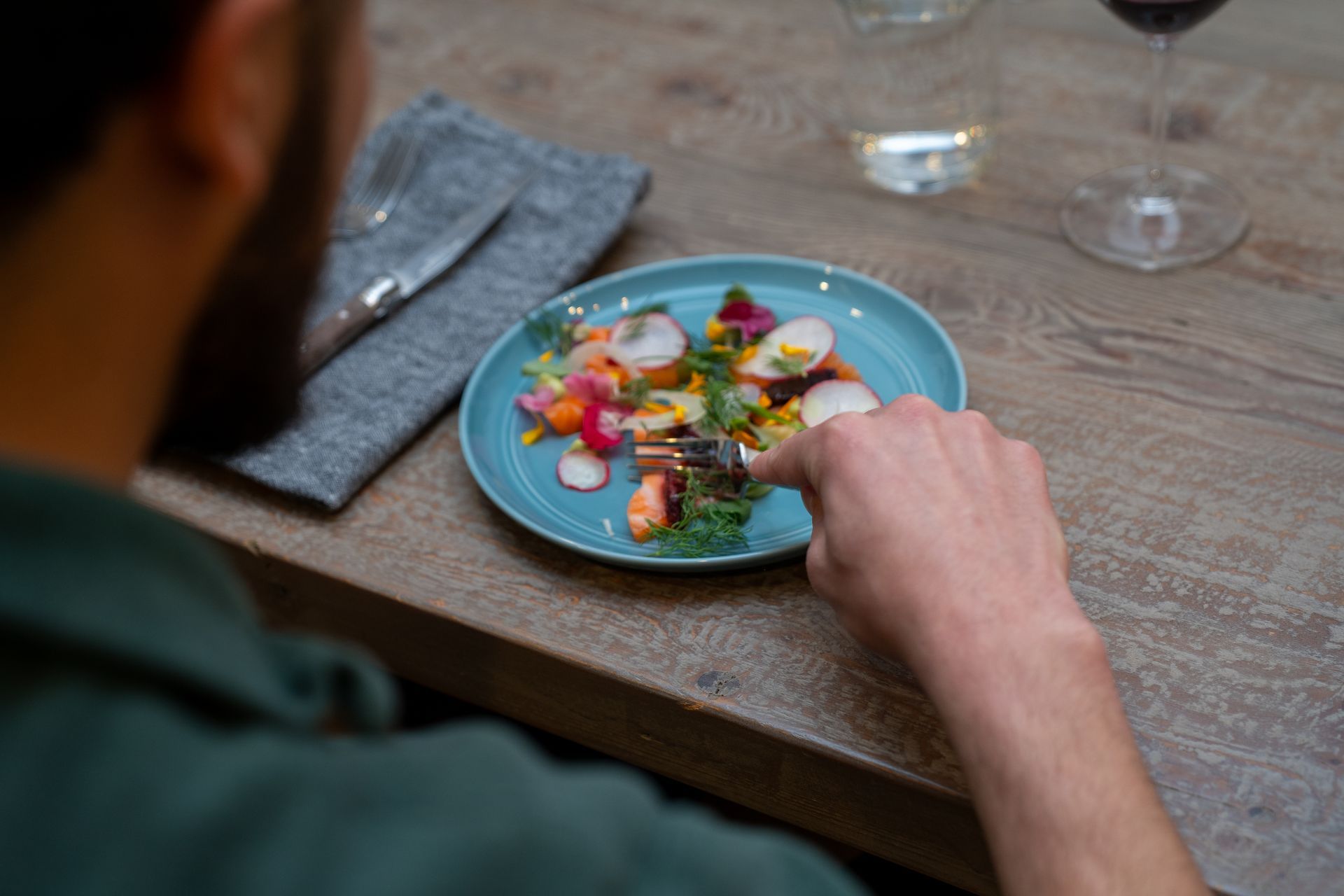 A man is sitting at a table eating a plate of food.