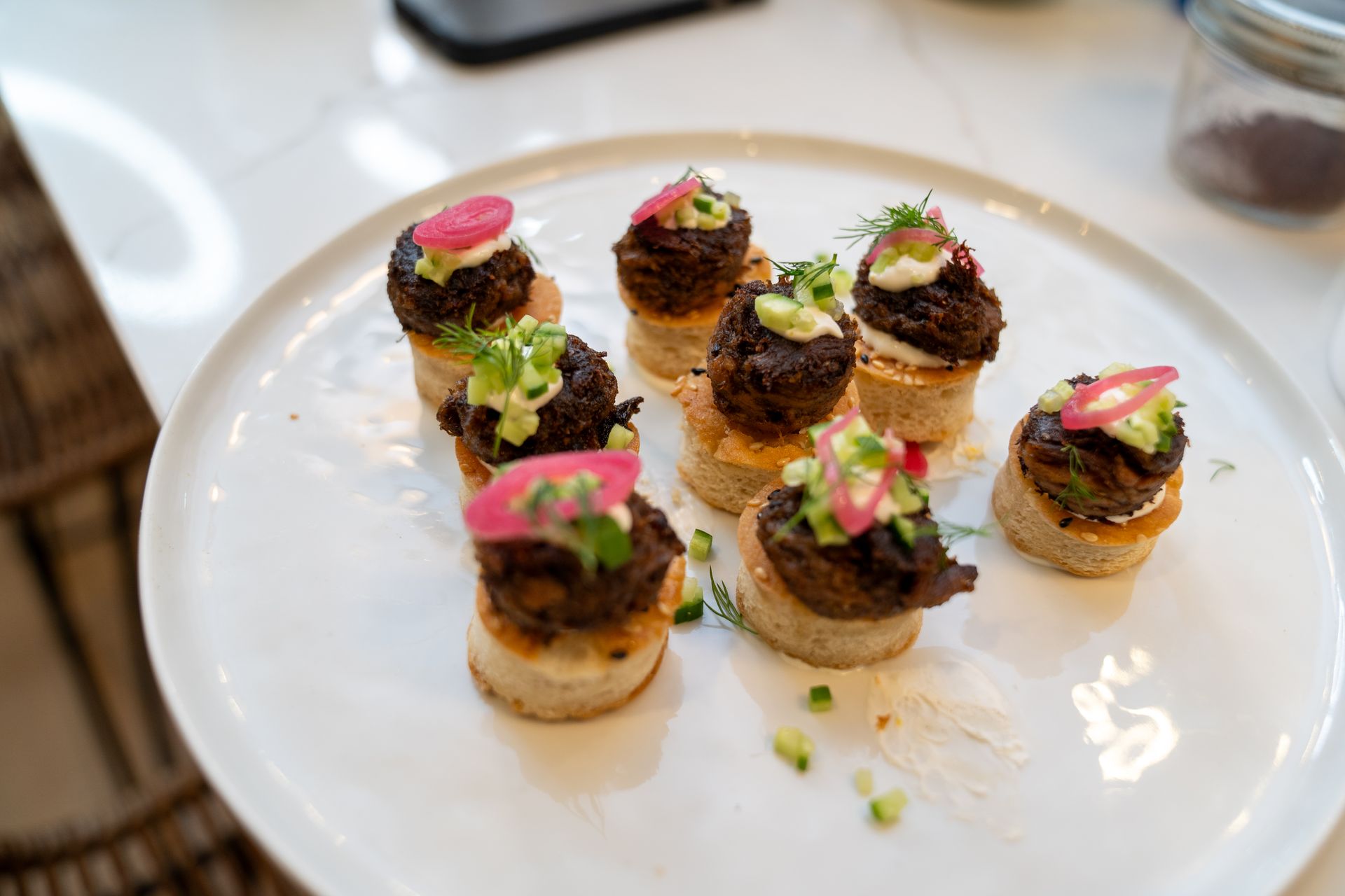 A white plate topped with small appetizers on a table.