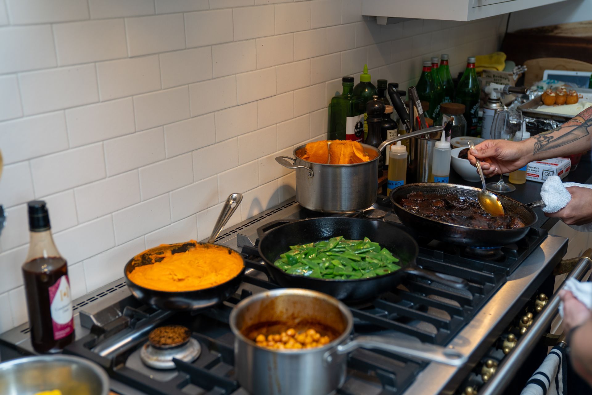 A person is cooking food on a stove in a kitchen.