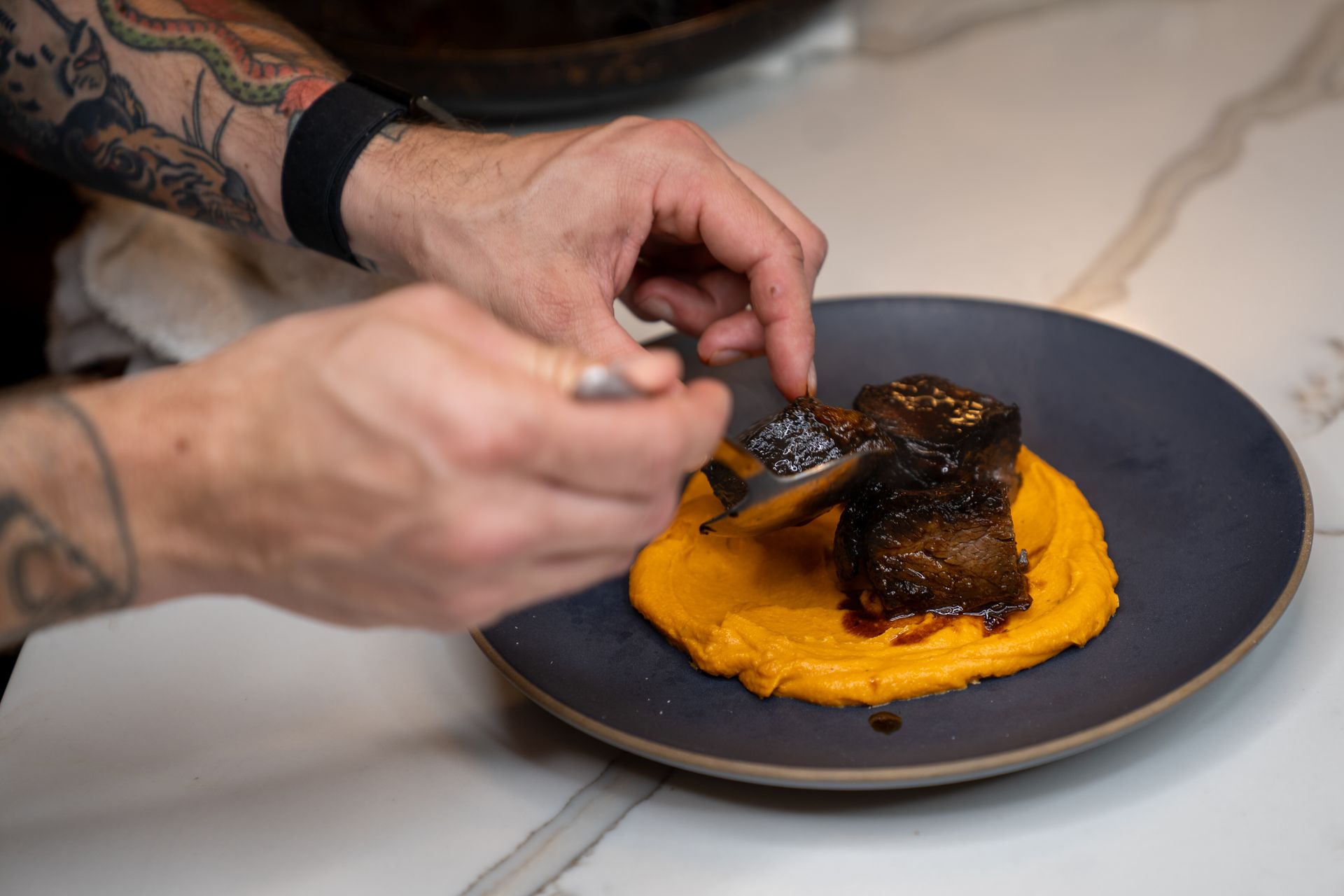 A man is preparing a plate of food on a table.