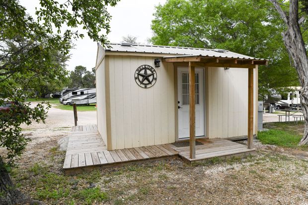 A small white shed with a texas star on the wall
