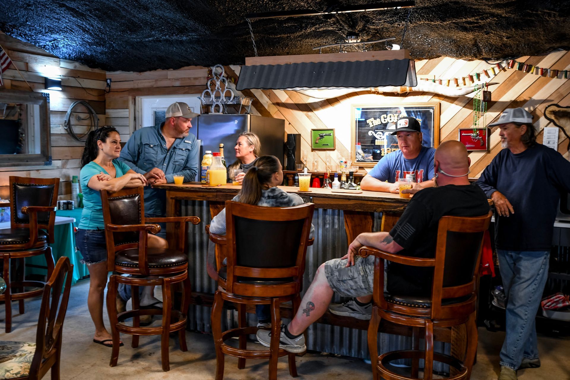 A group of people are sitting at a bar in a restaurant.