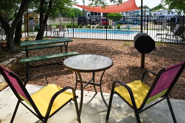 Two chairs and a table in front of a pool
