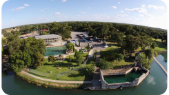 An aerial view of a park surrounded by water and trees.
