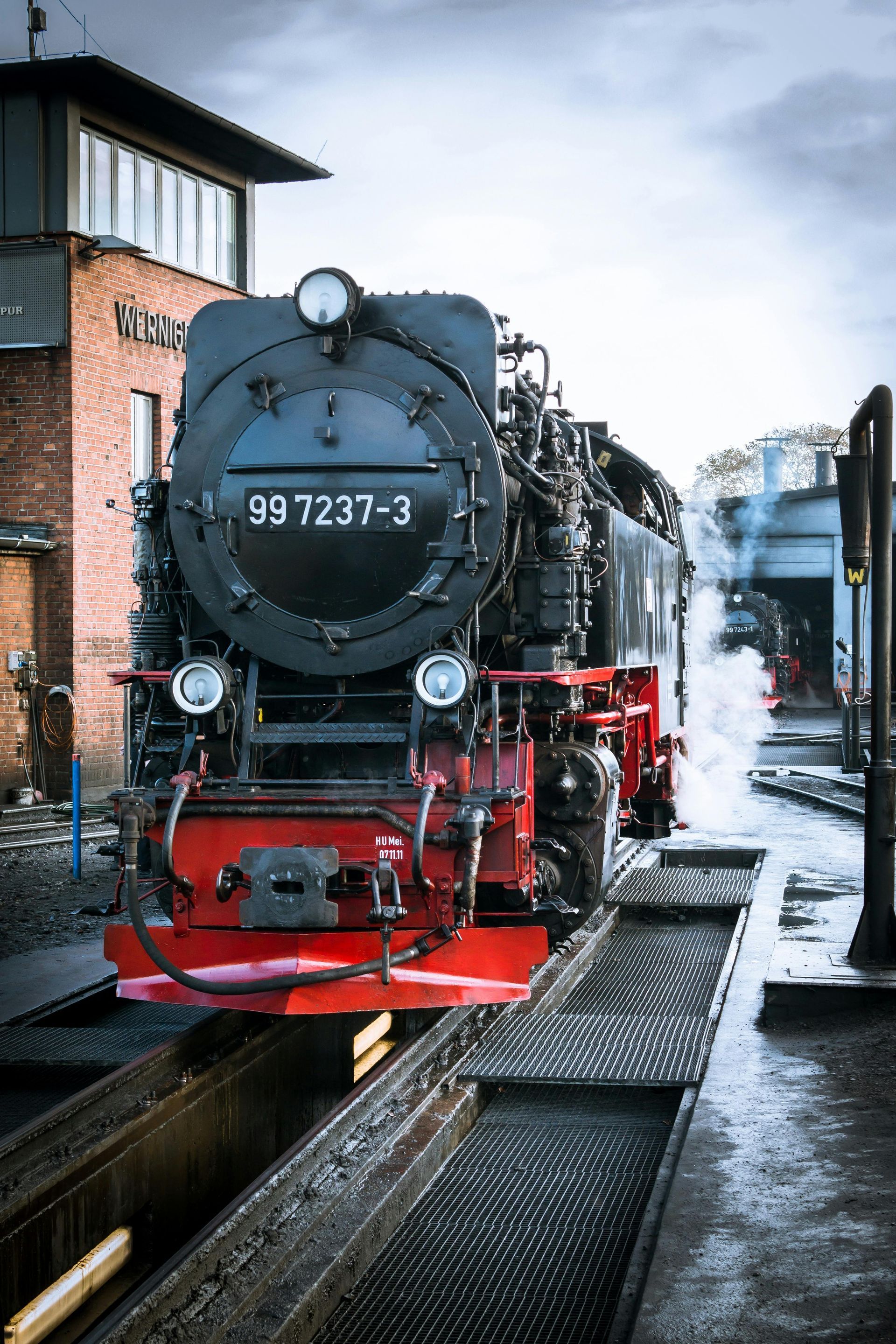 A black and red train is sitting on the tracks.