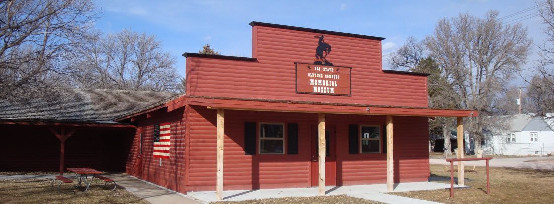 Red building with a cowboy silhouette. Building has porch and a sign that reads
