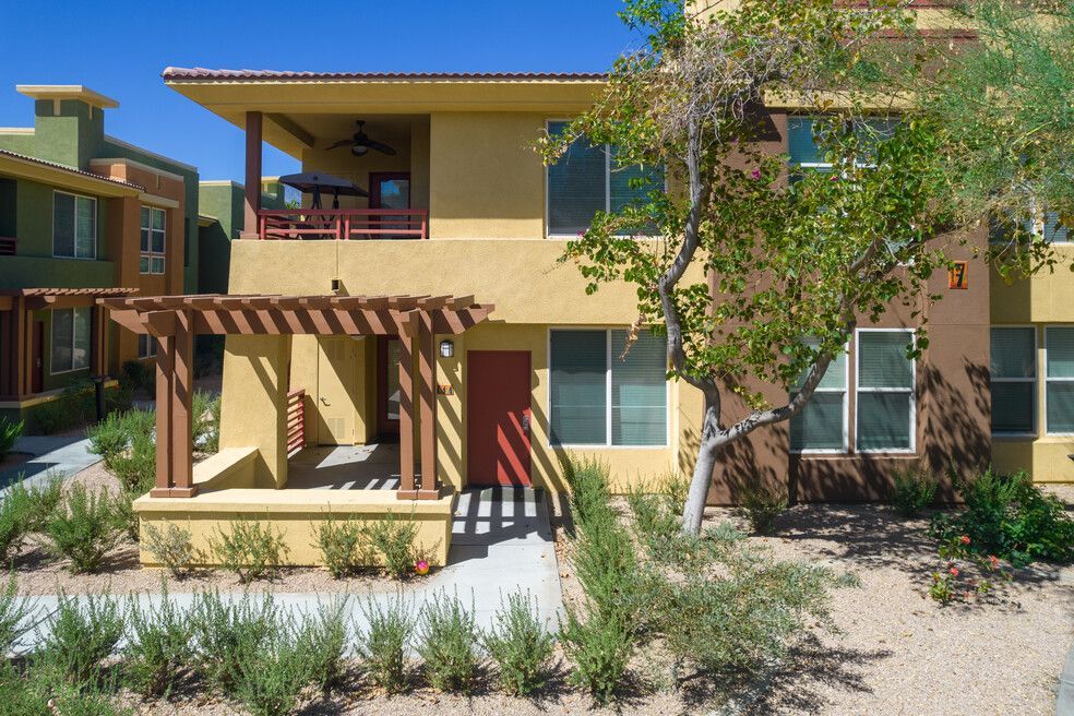 A large apartment building with a pergola and a red door