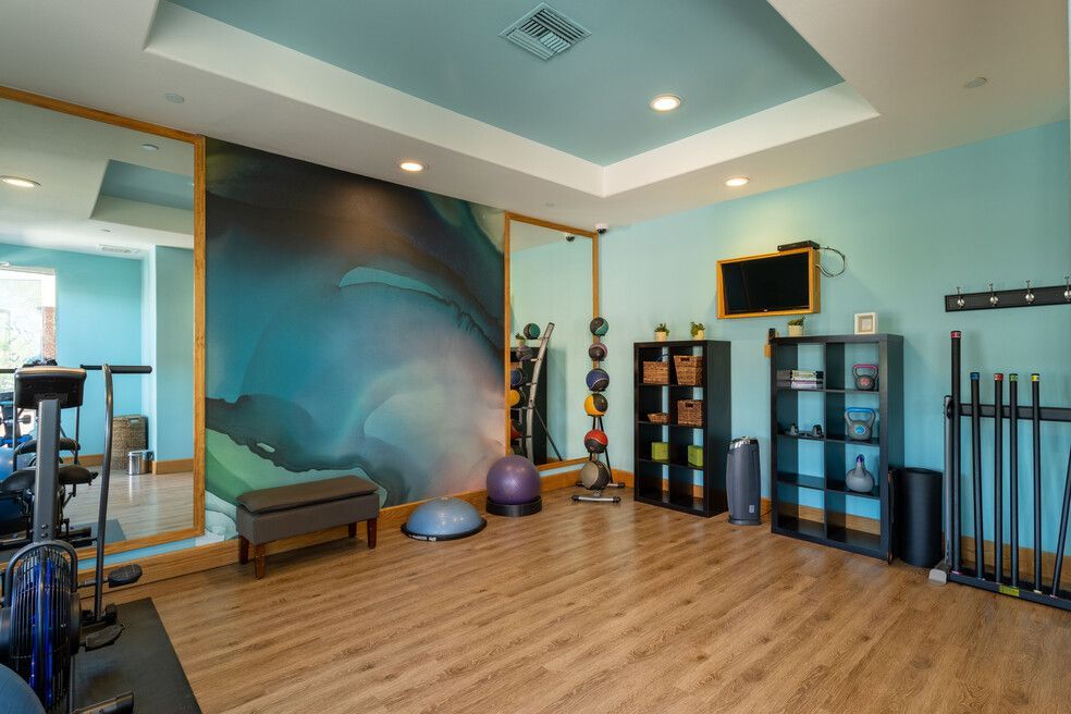 A gym with a lot of equipment and a large mirror.