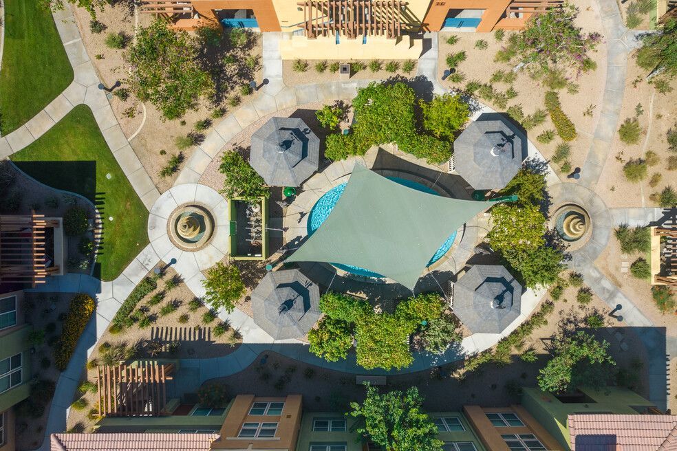 An aerial view of a park with a pool and umbrellas