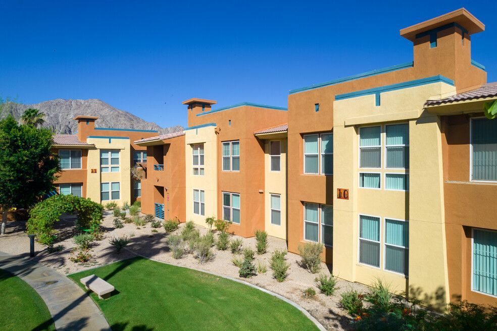 A row of apartment buildings with mountains in the background