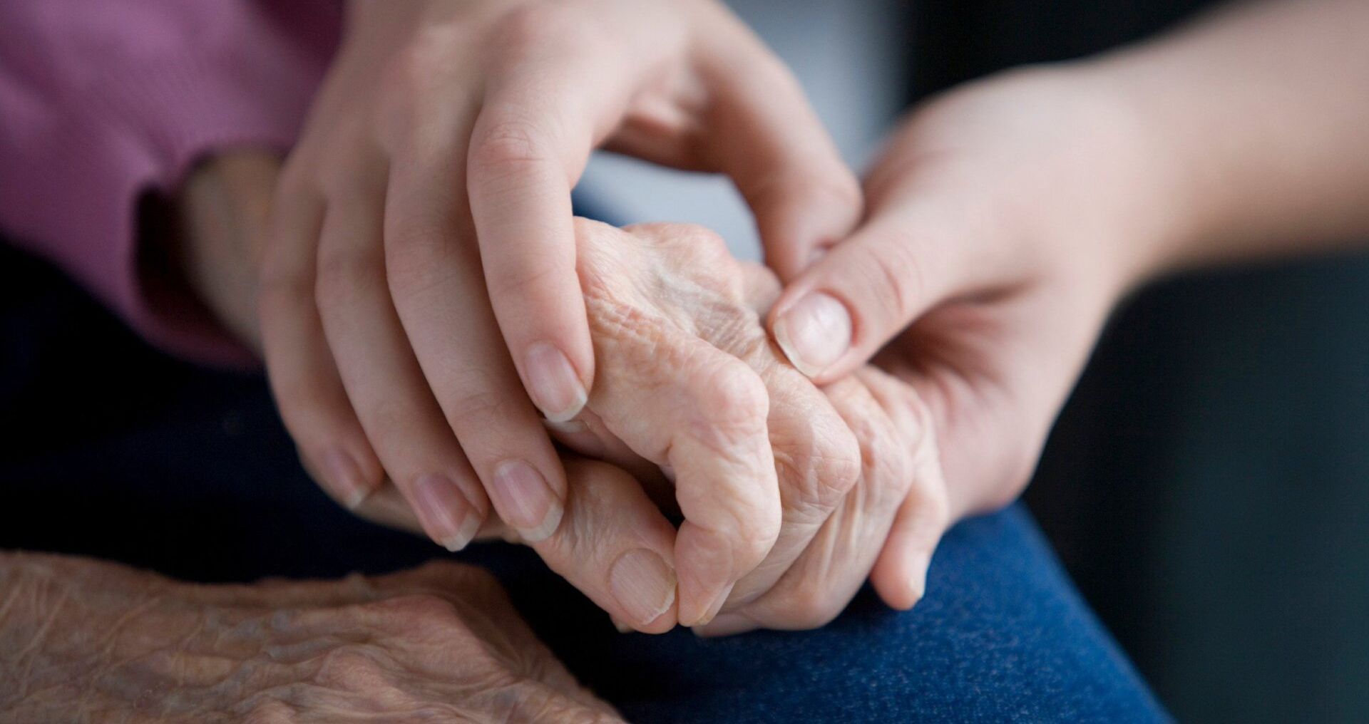 younger and older person holding hands