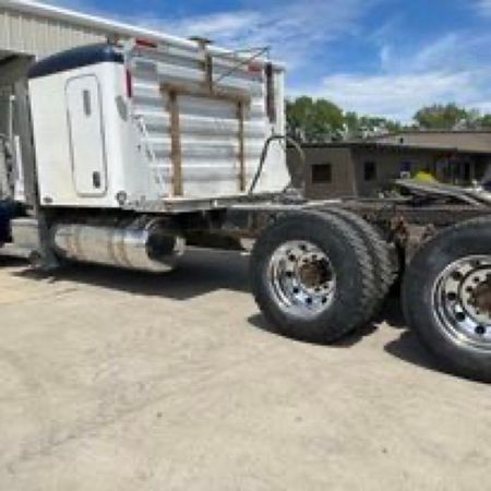 A semi truck with a trailer attached to it is parked in a parking lot.