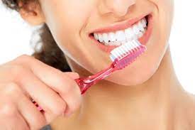 Woman brushing teeth after learning about preventative dental care in Topeka KS