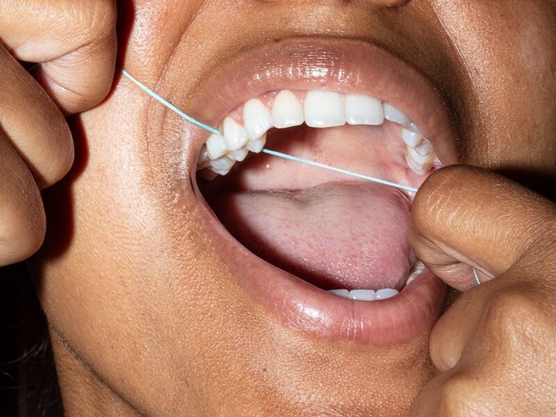 Woman flossing her teeth.