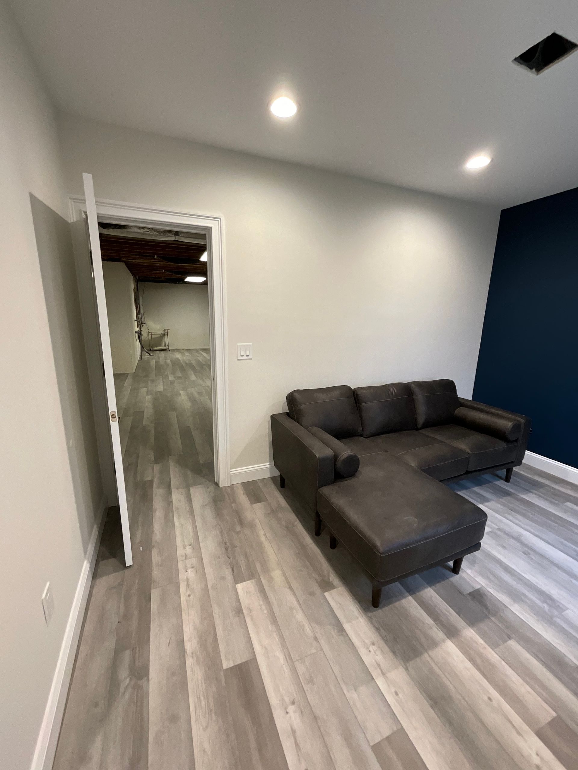 A living room with a couch and ottoman in it.