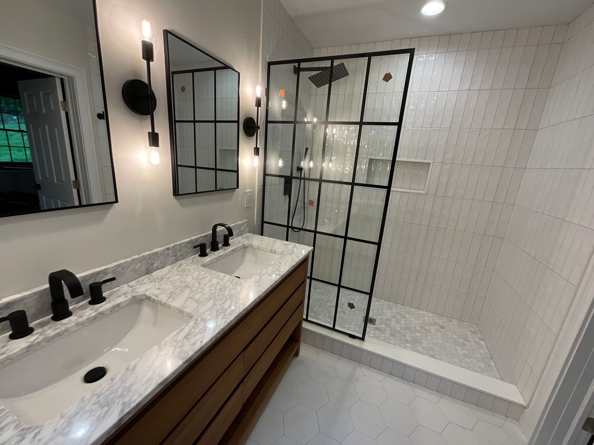A bathroom with two sinks and a walk in shower.