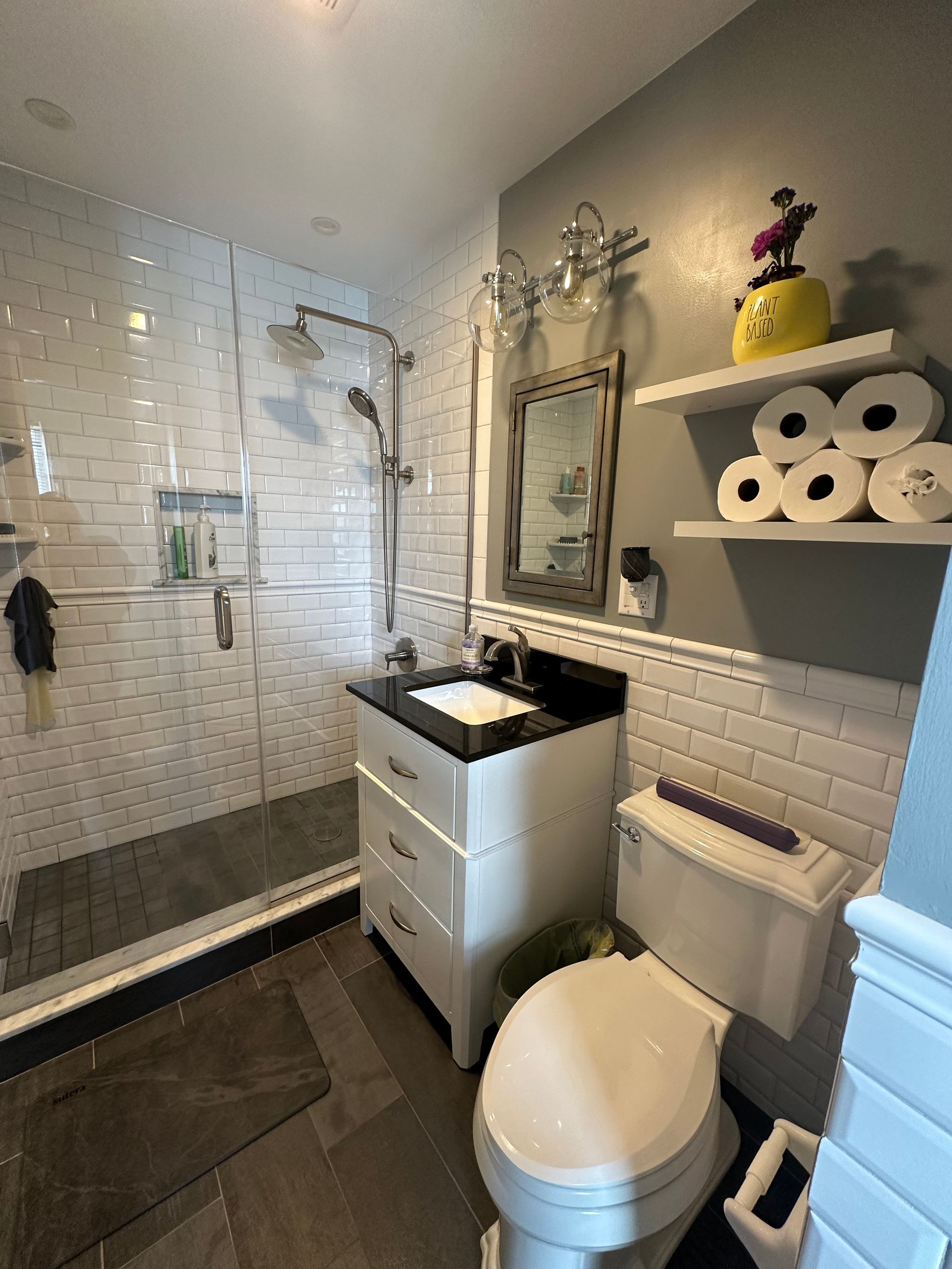 A bathroom with a toilet , sink and shower.