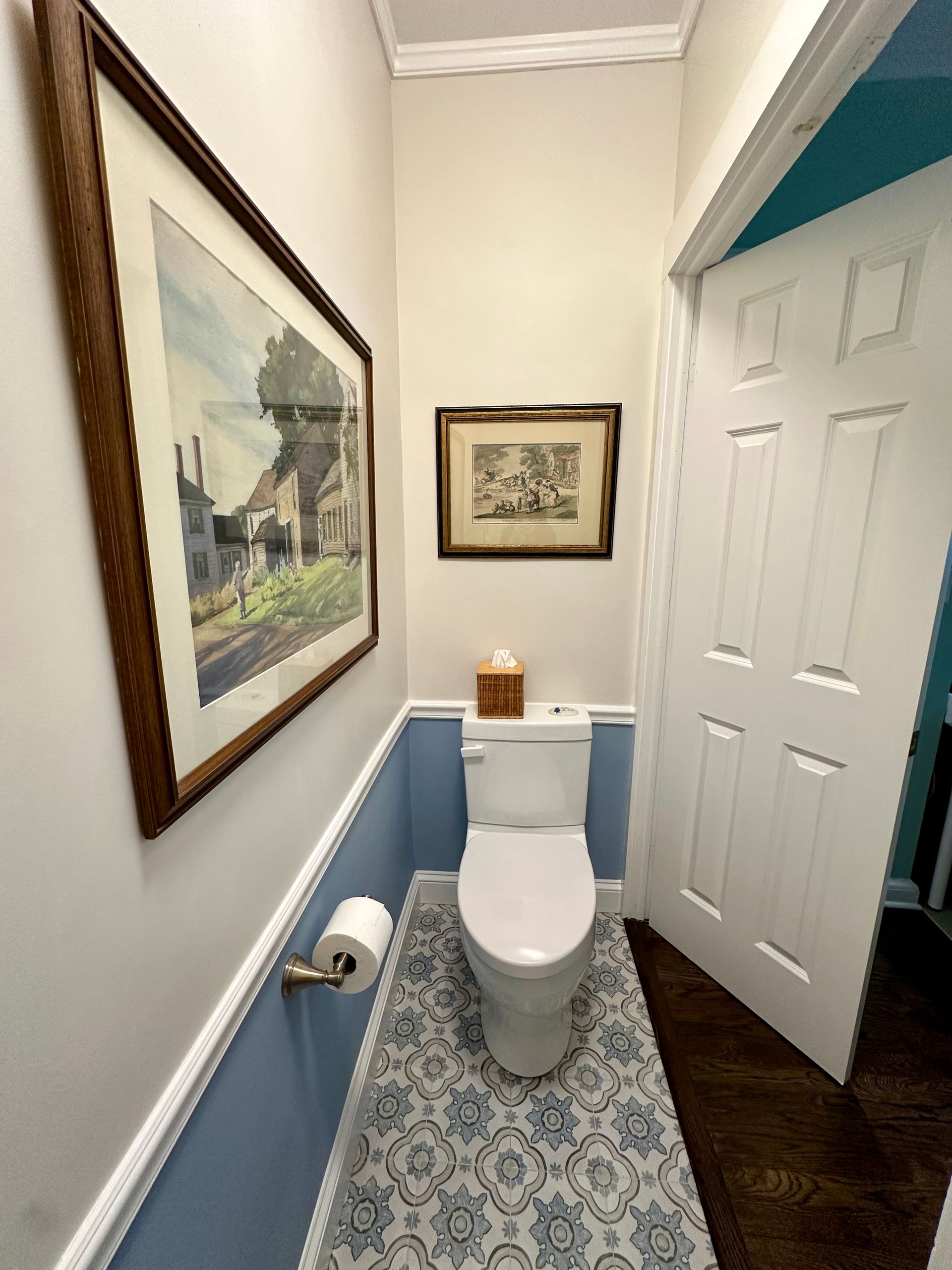 A bathroom with a toilet and a picture on the wall