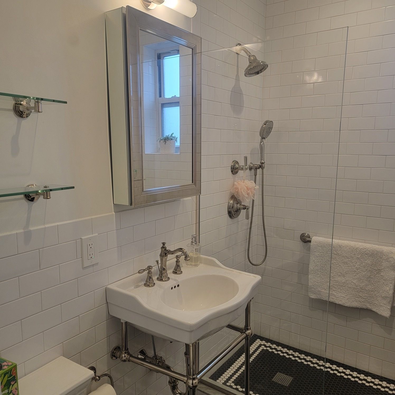 A bathroom with a sink , toilet , shower and mirror