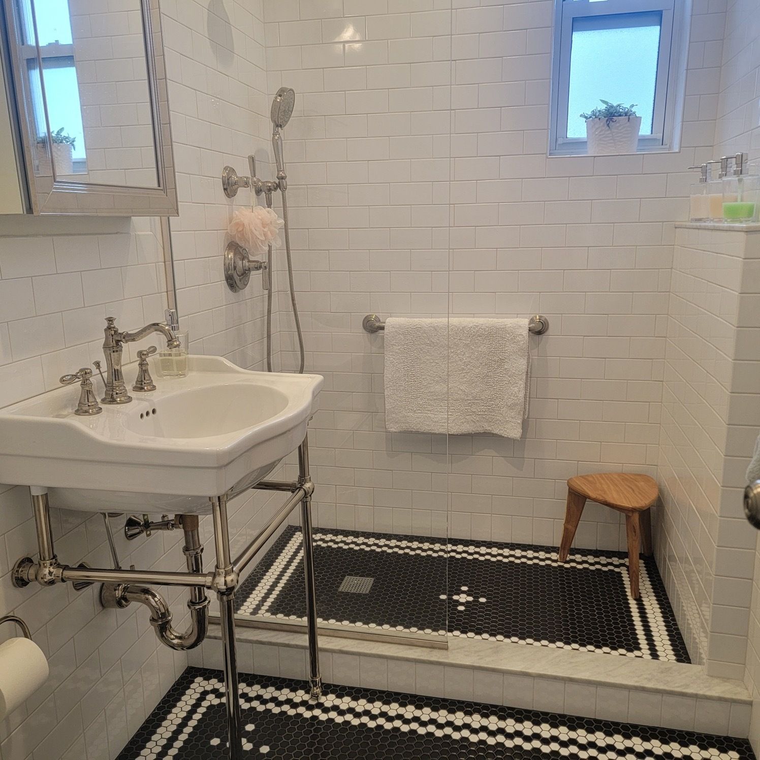 A bathroom with a sink a mirror and a shower