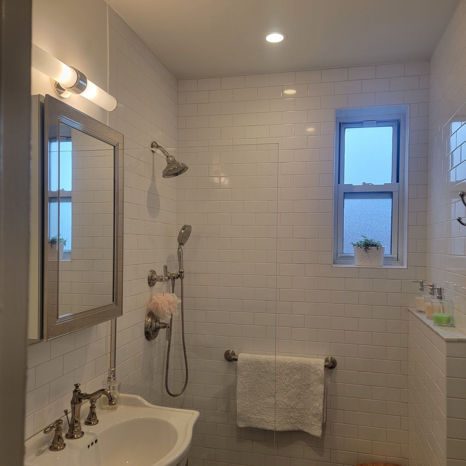 A bathroom with a sink a mirror and a shower