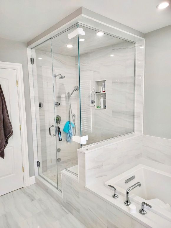 A bathroom with two sinks and a walk in shower.