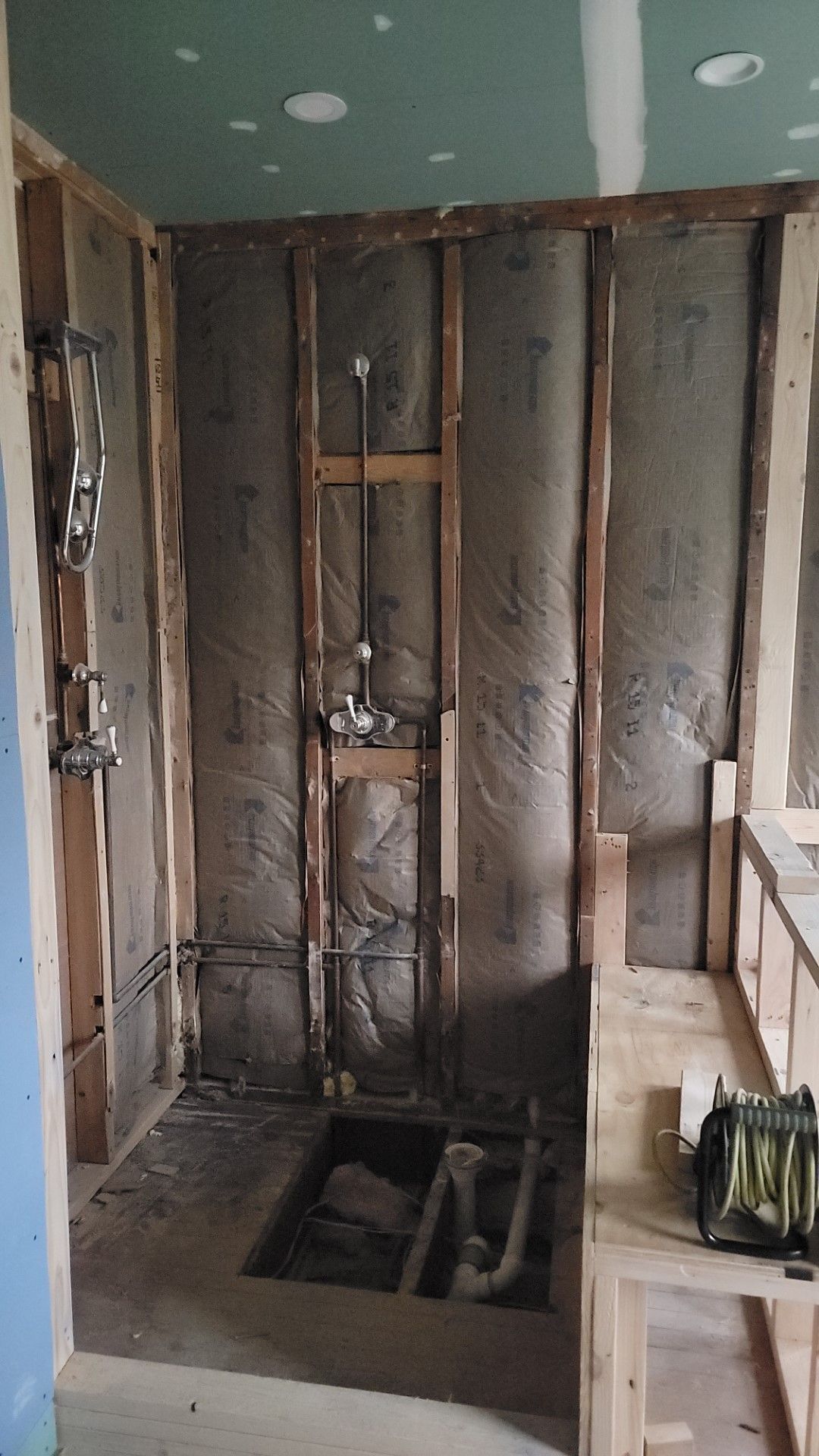 A bathroom under construction with a sink and a shower.