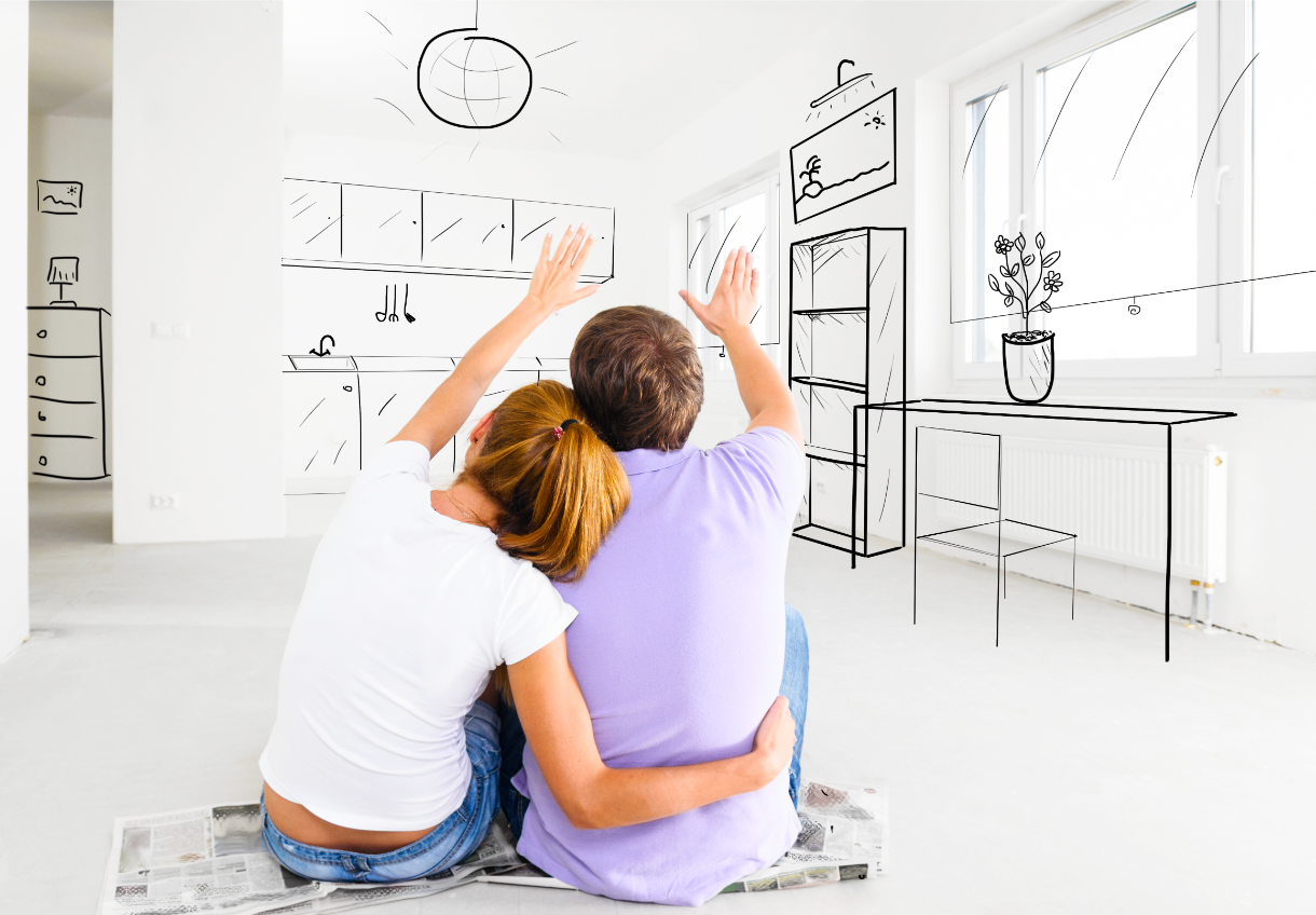 A man and a woman are sitting on the floor looking at a drawing of their new home.