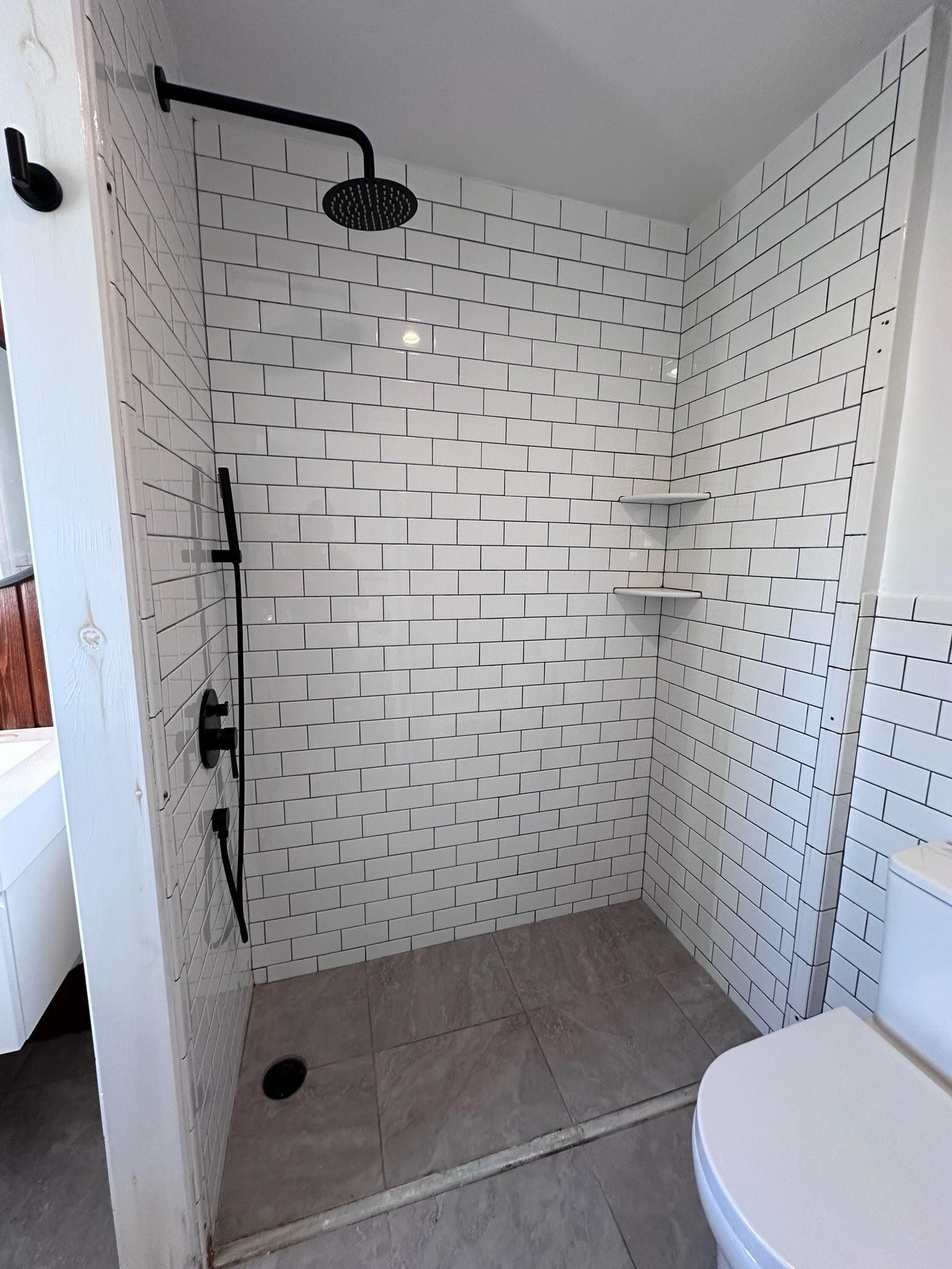 A bathroom with a walk in shower and a toilet.