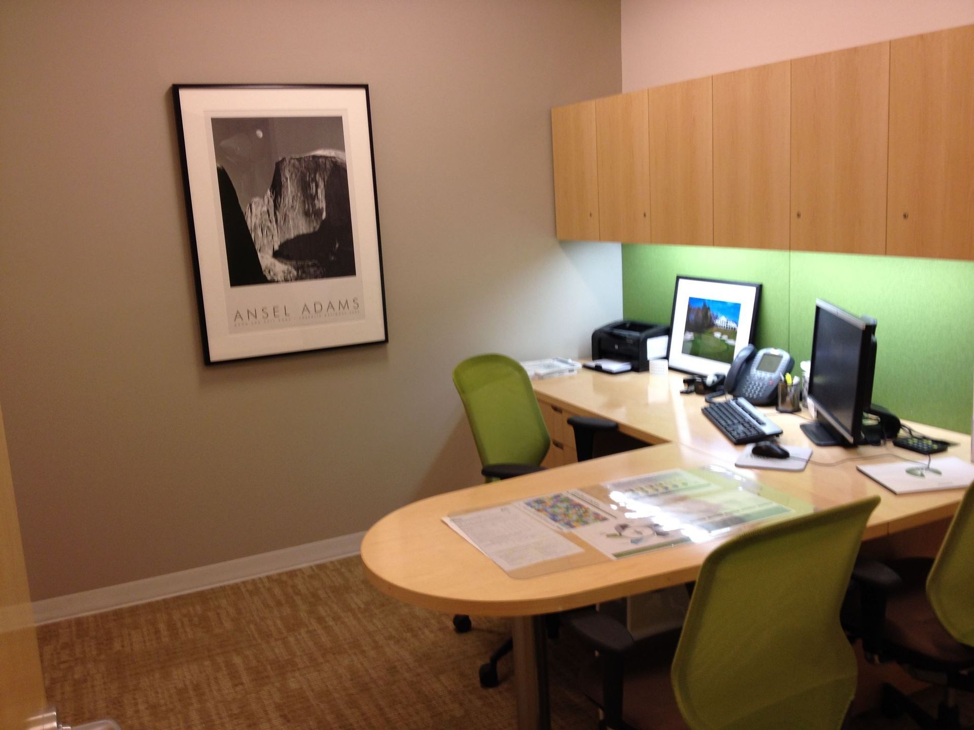 An office with a picture of yosemite on the wall