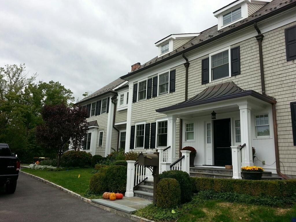 A large house with a black truck parked in front of it