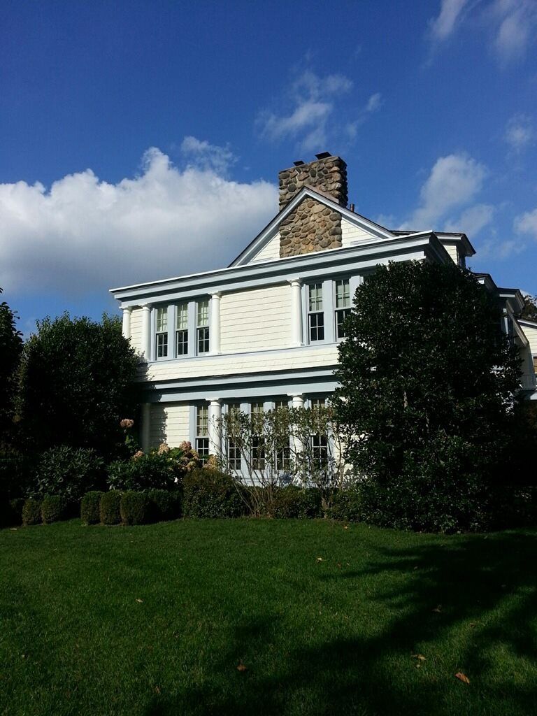 A large white house with a stone chimney on top of it