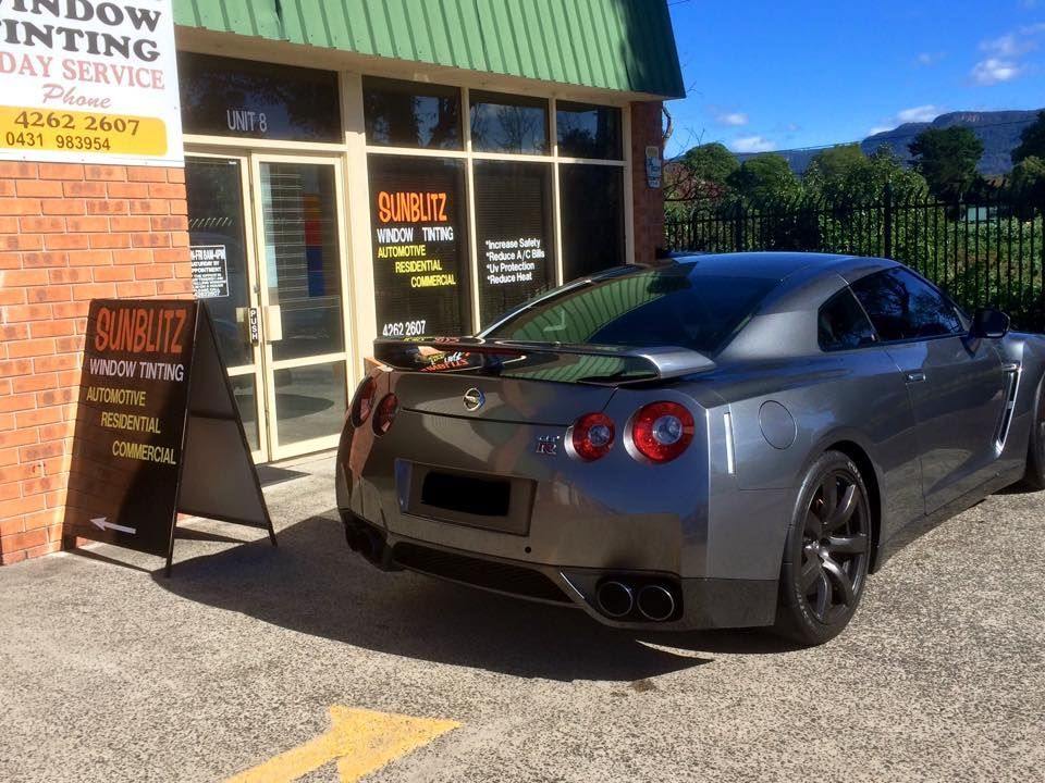 A Car Is Parked Outside A Tinted Car Shop— Sunblitz Window Tinting In Dapto, NSW