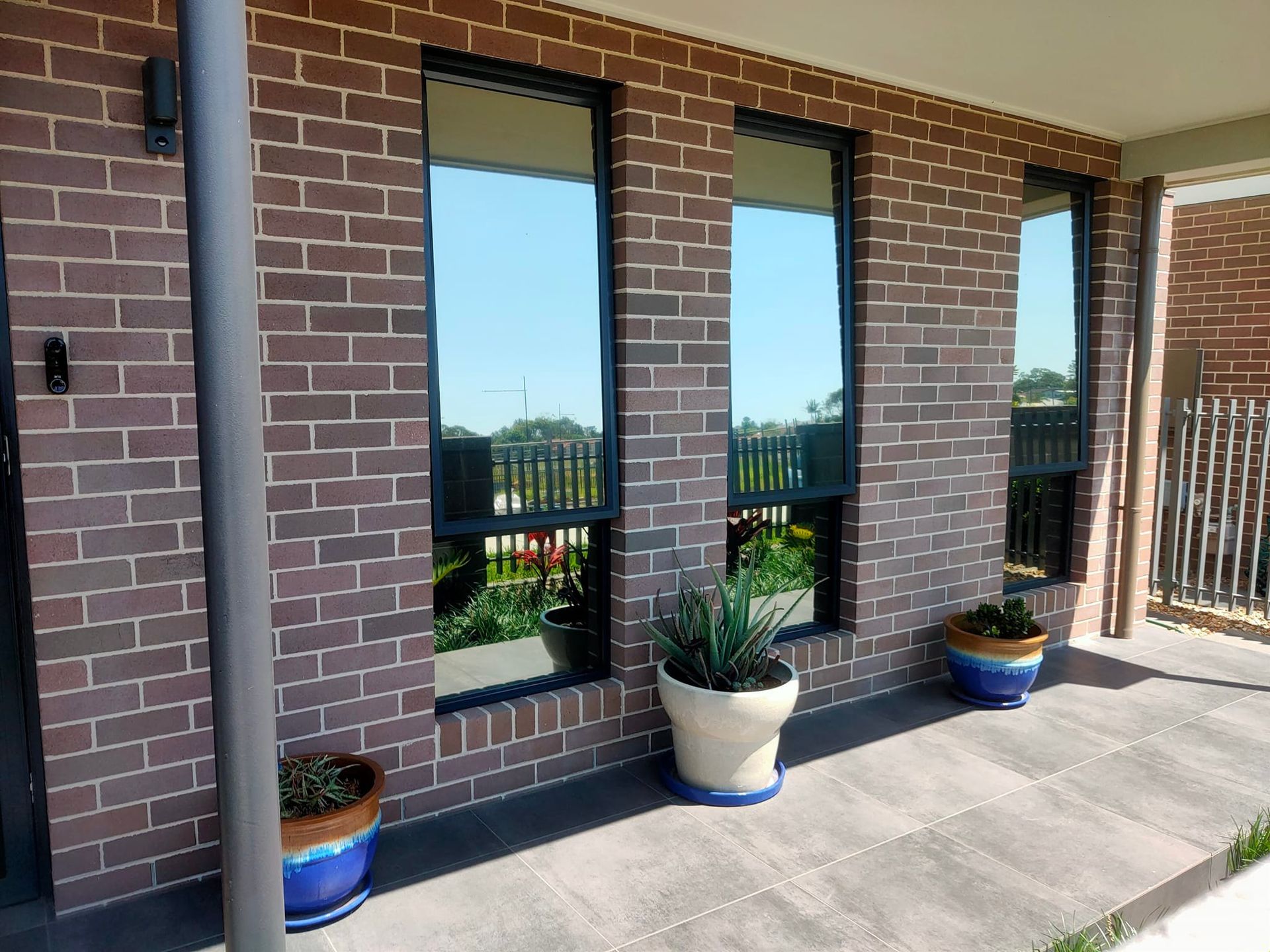 Outide Of A House With Tinted Windows And Brick Wall — Sunblitz Window Tinting In Dapto, NSW