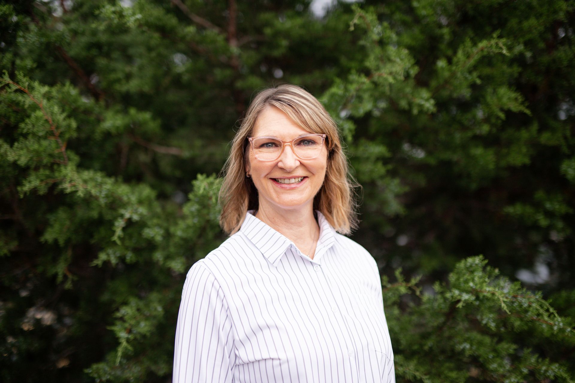A woman is wearing a t-shirt that says `` i teach tiny humans about jesus ''.