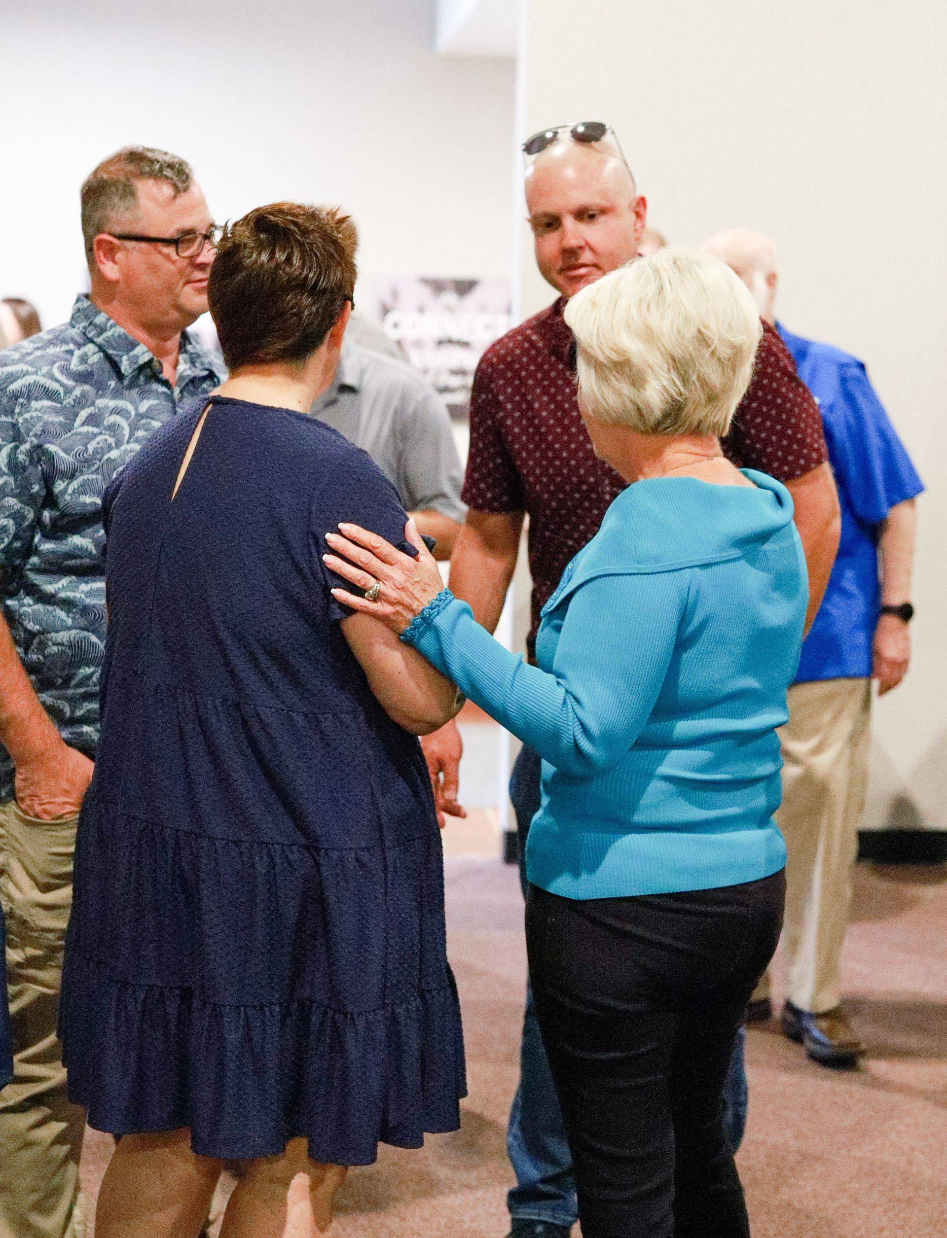 A man playing a guitar and a woman singing in front of a banner that says mighty