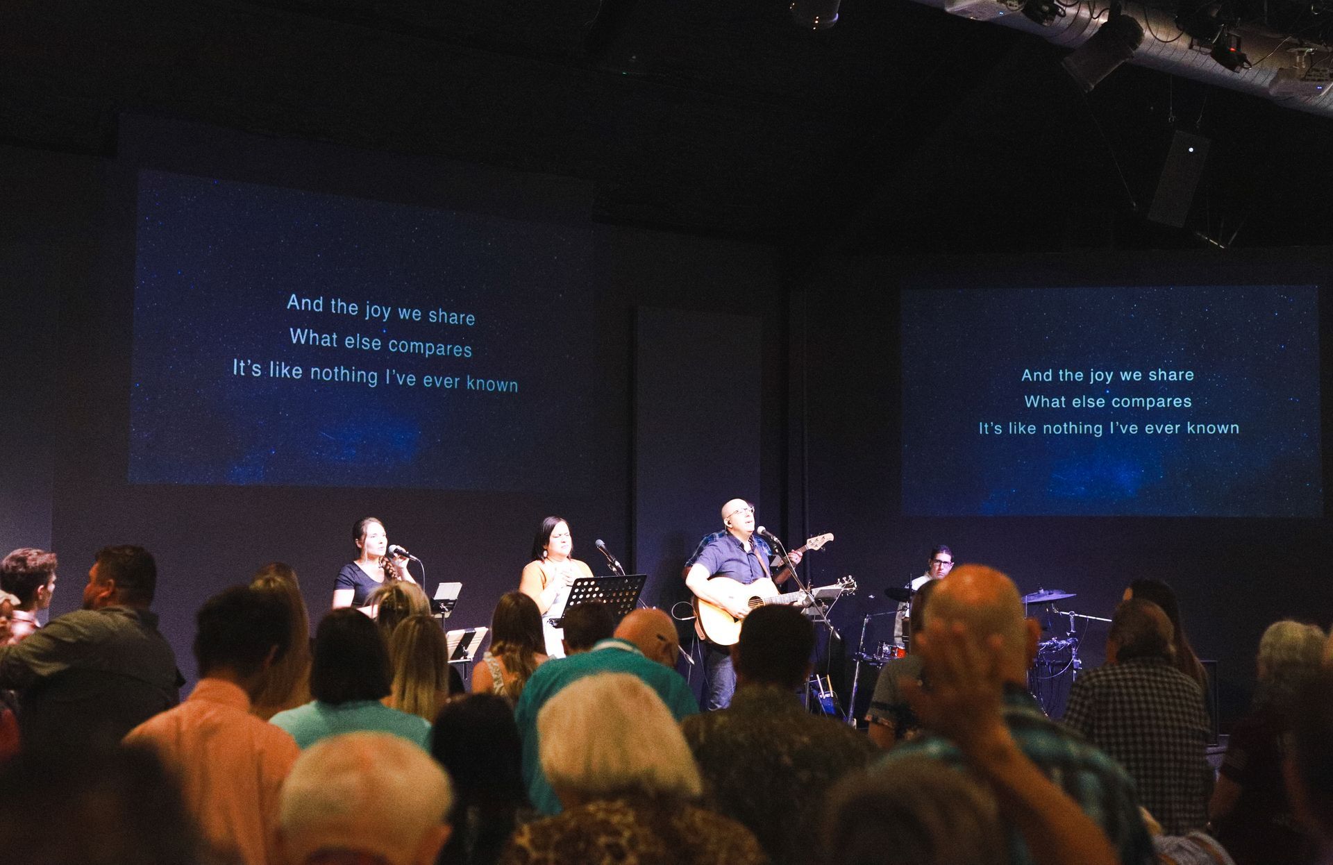A black and white photo of a group of people sitting in a living room