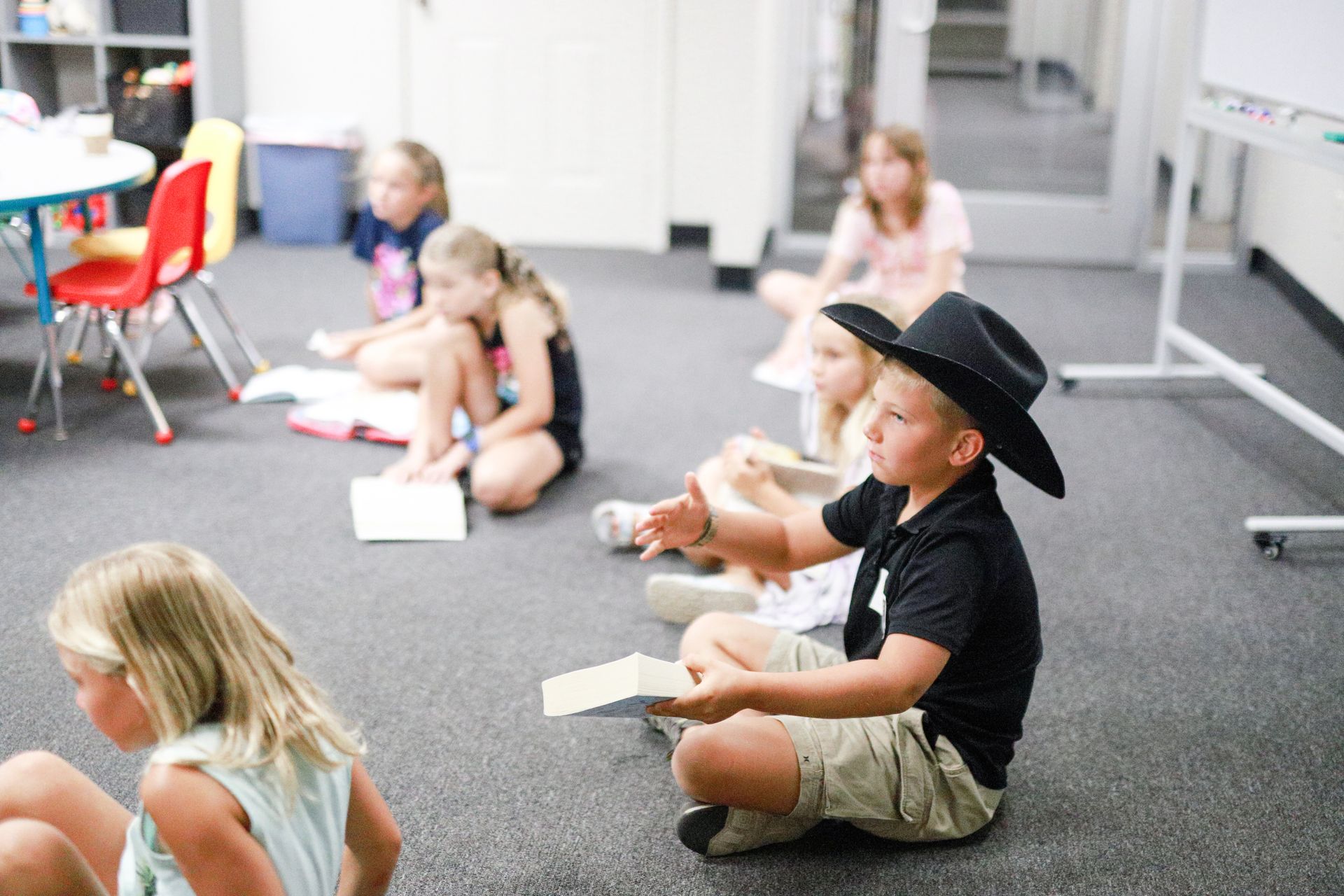 A little girl is sitting at a table playing with toys