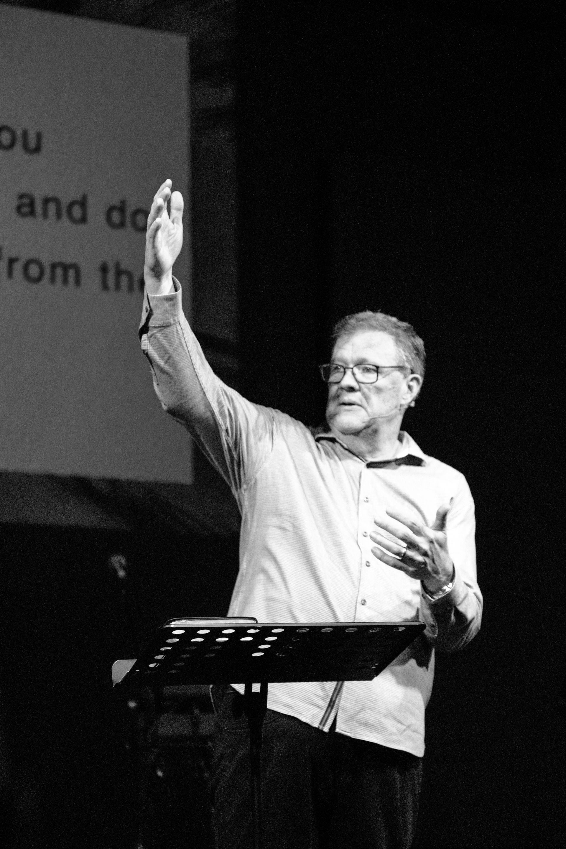 A black and white photo of a group of people sitting in a living room