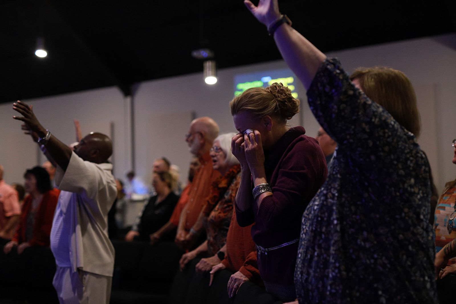 A group of people are posing for a picture in front of a body of water.