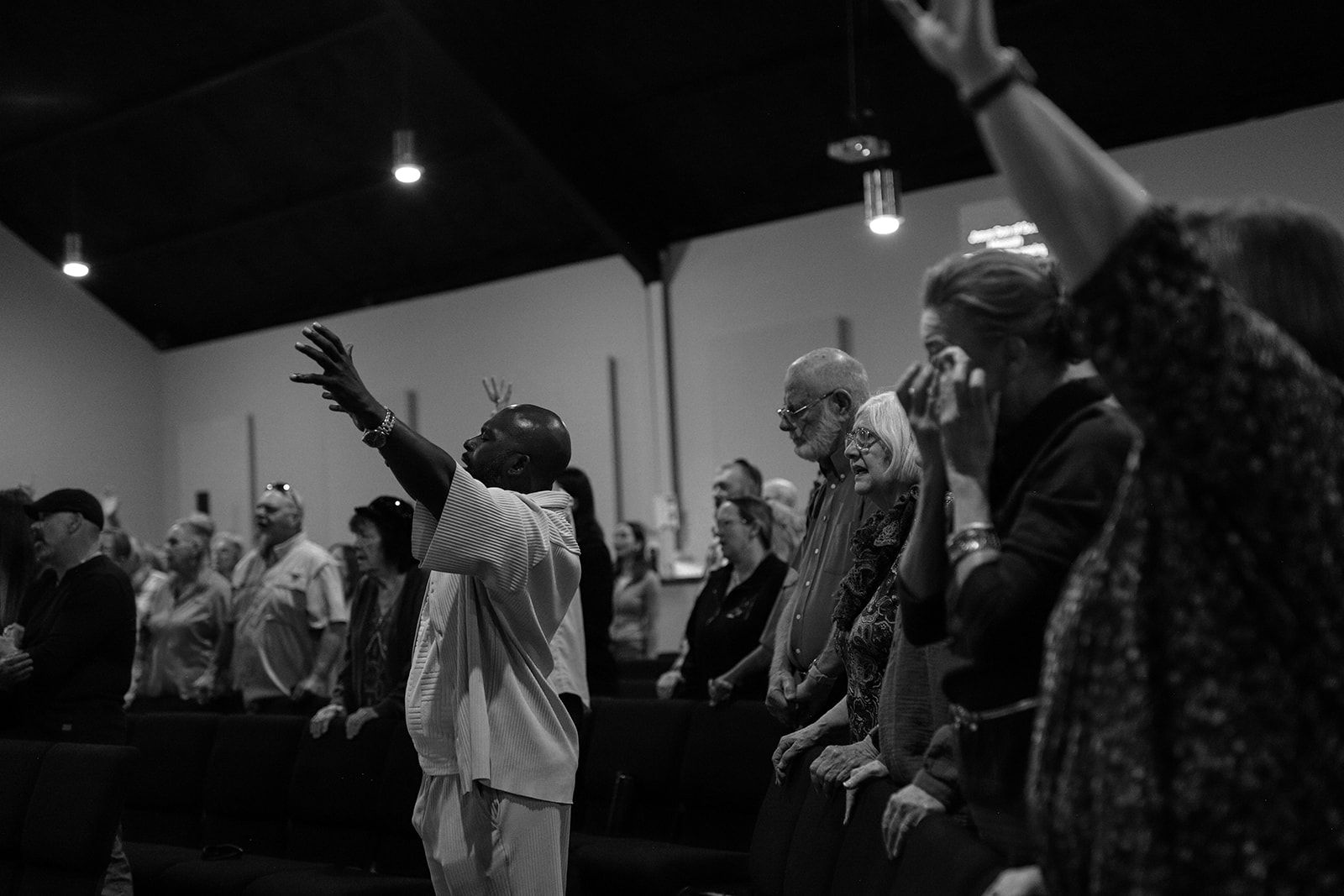 A group of people are posing for a picture in front of a body of water.