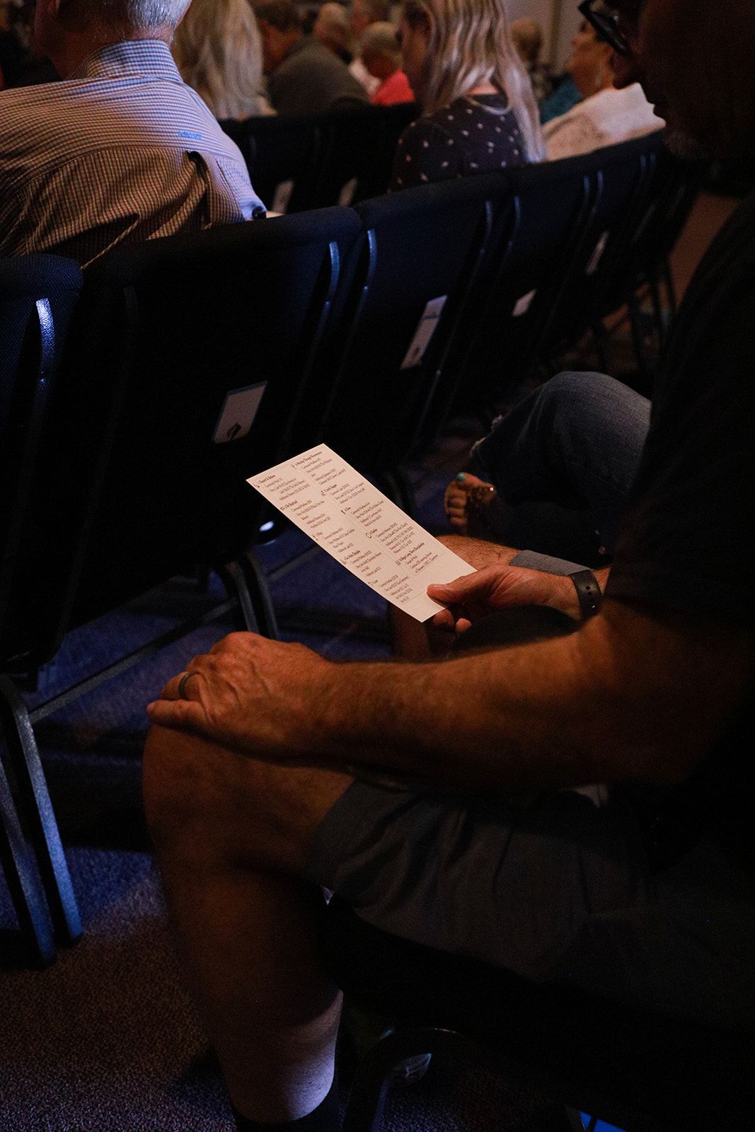 A woman is sitting on the floor reading a book.