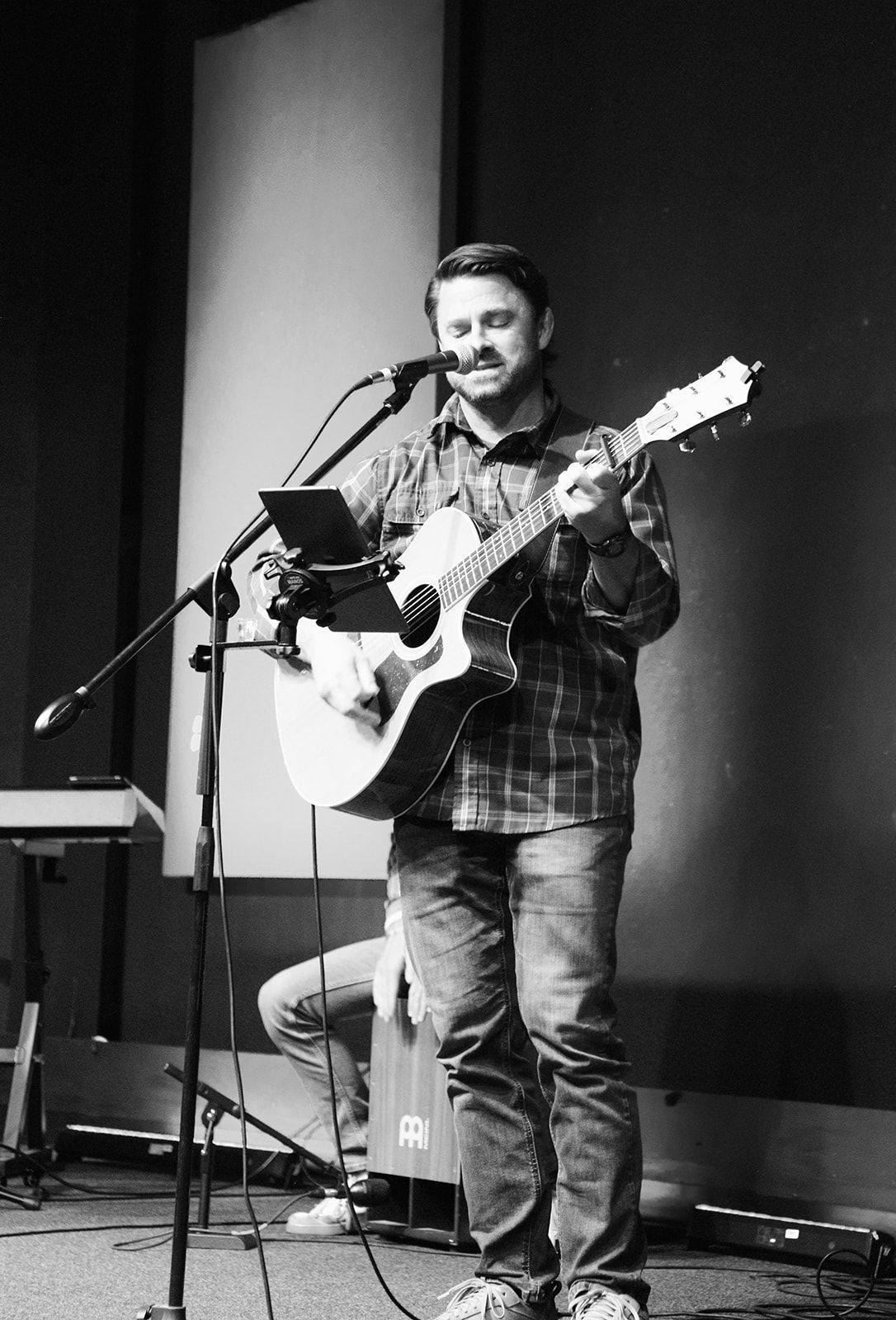 A man in a cowboy hat is talking to two other men