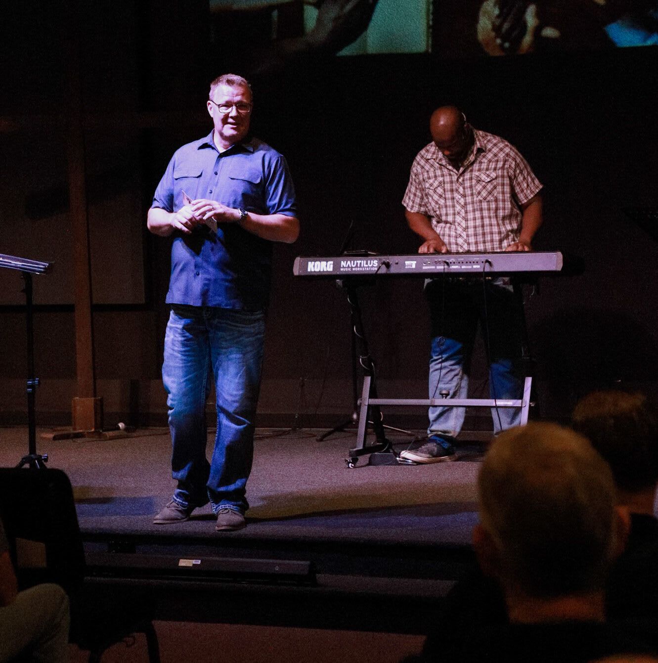 A man standing in front of a korg keyboard