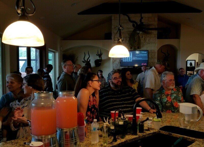 A group of people are sitting at a table in a kitchen.